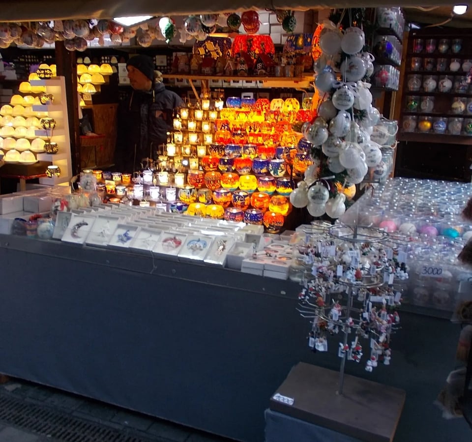 A Christmas market stall in Budapest filled with glass ornaments, candles and lights