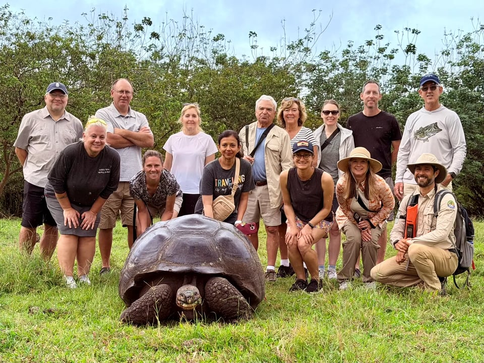 Journey with Erika travelers gathered around a giant Galápagos tortoise with their naturalist guide