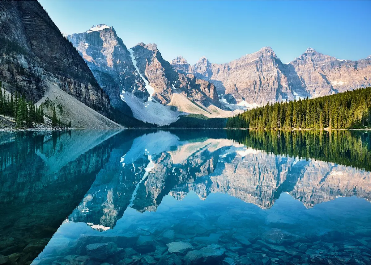 Snowy Rocky Mountain peaks reflected in the turquoise water of Moraine Lake