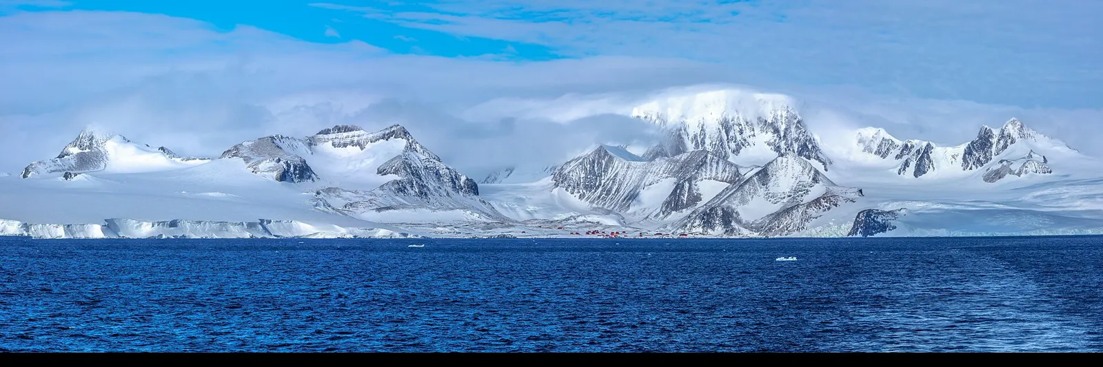 Snow-covered Antarctic mountains rising above an icy sea