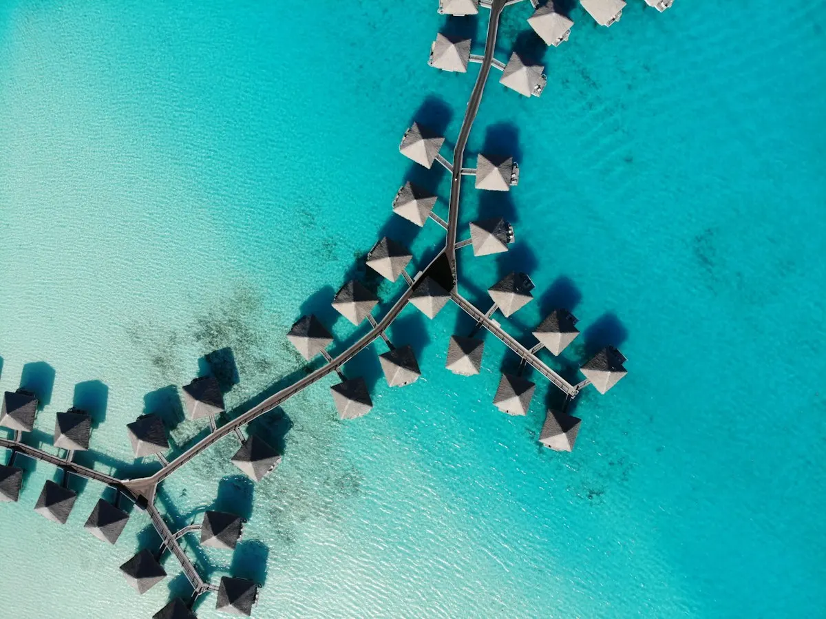 Aerial view of overwater bungalows on a turquoise lagoon