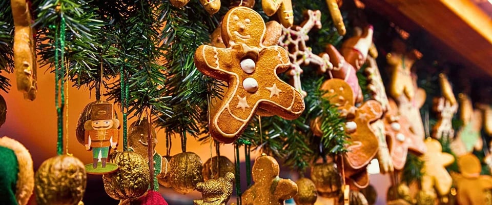 Gingerbread cookies and golden ornaments hanging on a Christmas tree