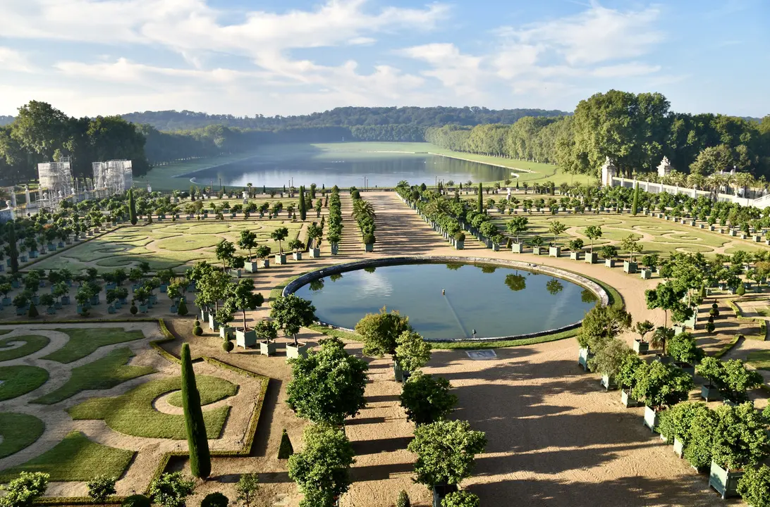 The formal gardens and orangery of the Palace of Versailles on a sunny morning